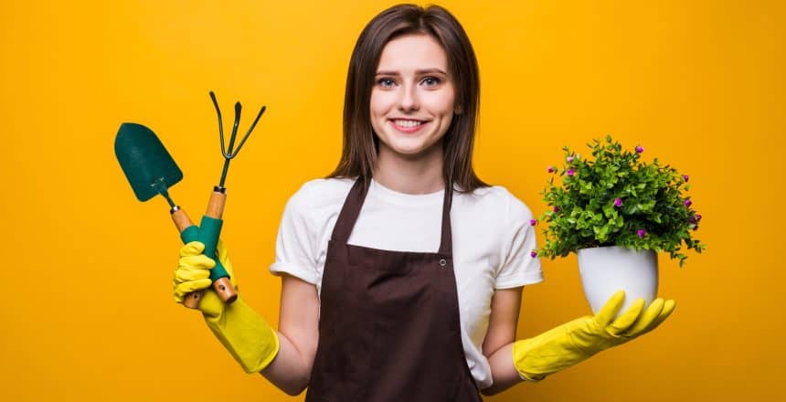 Young woman holding a plant isolated on yellow background